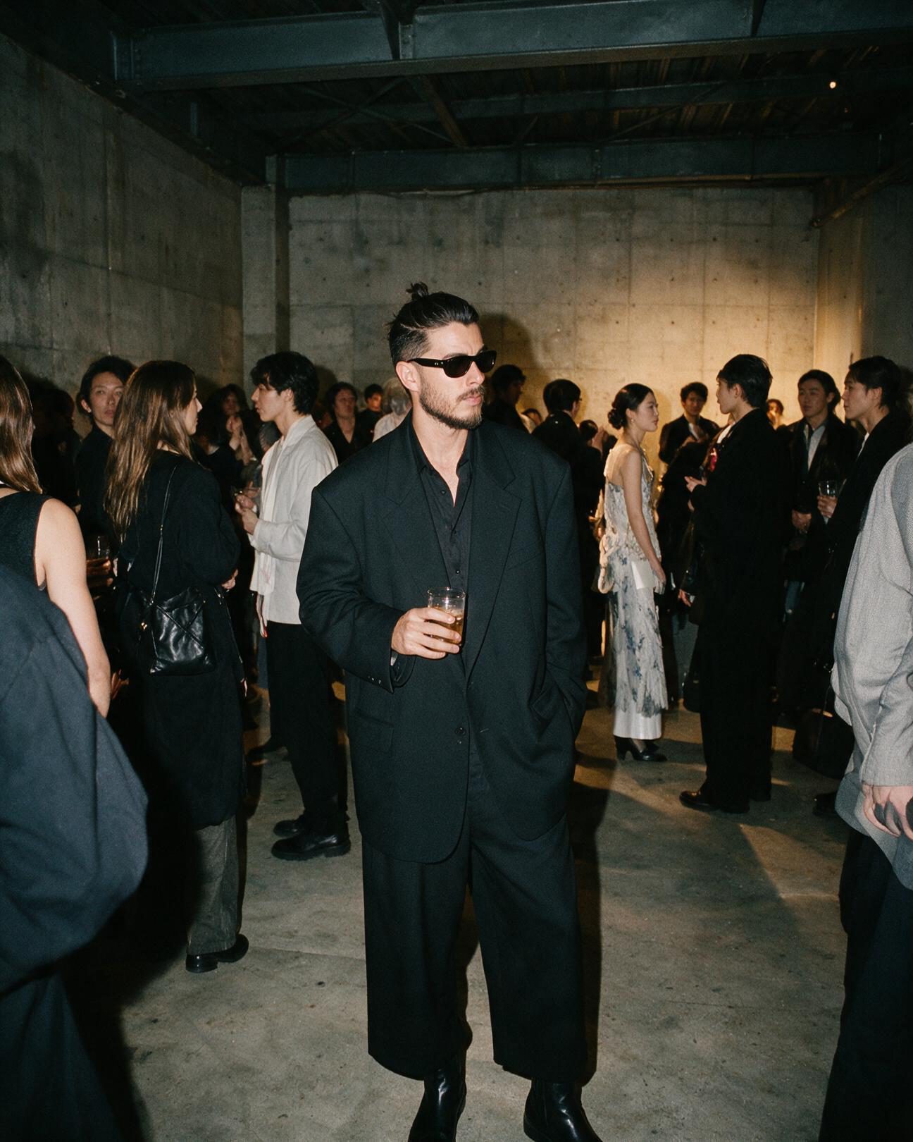 Xavier Roca at a gallery event, holding a drink